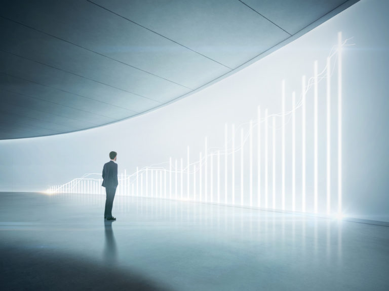 Businessman looking at shining chart on the wall