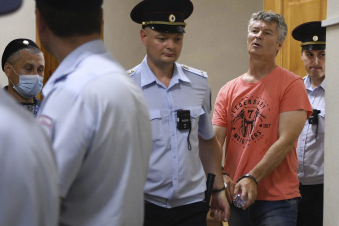 The police escort Yekaterinburg ex-mayor Yevgeny Roizman from the court room after a hearing in Yekaterinburg, Russia, Thursday, Aug. 25, 2022. The former mayor of Russia's fourth-largest city has been arrested on charges of discrediting the country's military