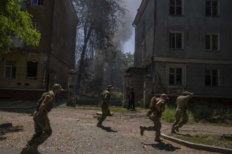 FILE - Ukrainian soldiers run after a missile strike hit a residential area, in Kramatorsk, Donetsk region, eastern Ukraine, Thursday, July 7, 2022. Injured residents sat dazed and covered in blood. A crater was now the centre of the courtyard. Last week, the governor of the Donetsk oblast Pavlo Kyrylenko urged the province's more than 350,000 remaining residents to flee to safer towns further West, saying that evacuating the region was necessary to save lives and allow the Ukrainian army to better defend towns against a Russian advance. Many refuse to leave the city. ()