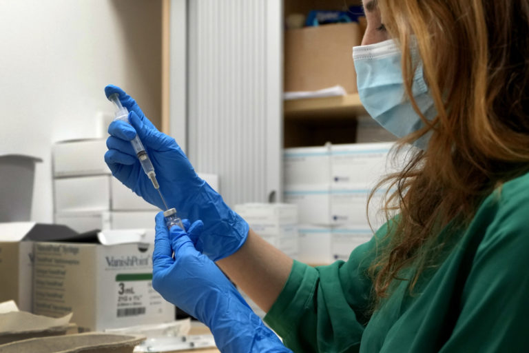 FILE - A Pfizer COVID-19 vaccine is prepared at St Charles' Centre for Health and Wellbeing in London, Friday, Dec. 3, 2021. Everyone in Britain who is 50 or over will be offered a fourth dose of coronavirus vaccine in the fall it was announced Friday, July 15, 2022, lowering the age threshold from the previously announced 65. The Department of Health said it had accepted advice from the U.K.’s independent vaccines adviser about the autumn booster program