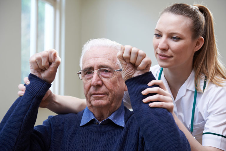 Nurse Assessing Stroke Victim By Raising Arms
