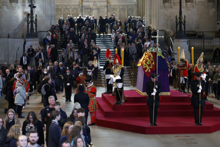 People pay their respect as they walk past Queen Elizabeth II's flag-draped coffin lying in state on the catafalque at Westminster Hall, in London