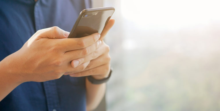 Close up businessman holding smartphone for checking work or make appointment and using application for manage job or surf the internet at outside office , technology lifestyle concept