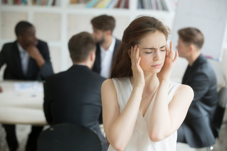Stressed female corporate employee having migraine during briefing.