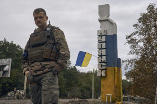 A Ukrainian soldier stands near the sign reading "Kupiansk" in the recently retaken Kupiansk in the Kharkiv region, Ukraine, Wednesday, Sept. 14, 2022. Ukrainian troops piled pressure on retreating Russian forces pressing deeper into occupied territory and sending more Kremlin troops fleeing ahead of the counteroffensive that has inflicted a stunning blow on Moscow's military prestige