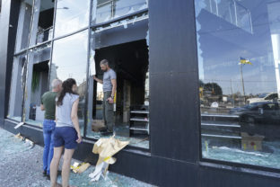 Shop owners inspect broken windows after the night Russian rocket attack in downtown Kharkiv, Ukraine