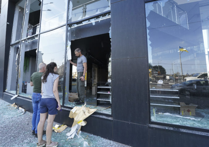 Shop owners inspect broken windows after the night Russian rocket attack in downtown Kharkiv, Ukraine