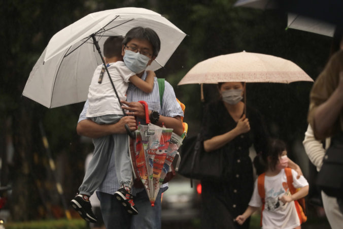 People walk in the rain ahead of the approaching Typhoon Muifa in Taipei, Taiwan