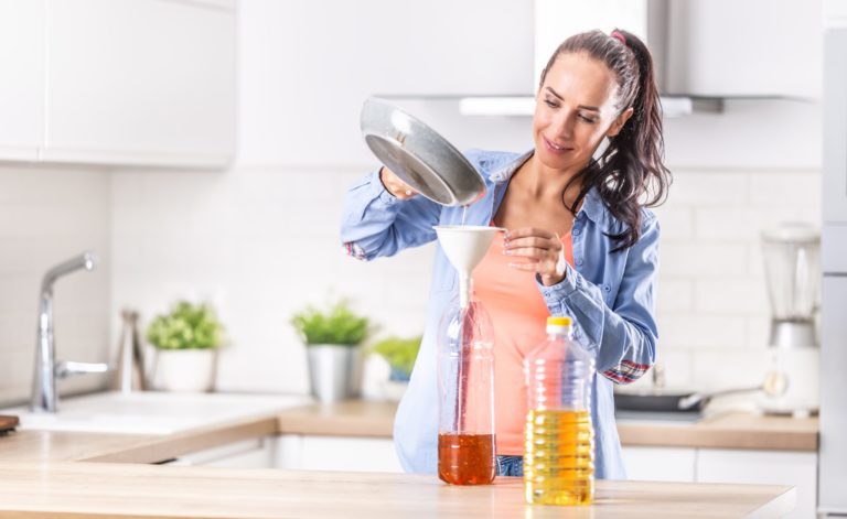 Woman,Pouring,Used,Cooking,Oil,For,Recycling,And,Reuse,Into