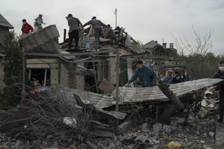 Volunteers work to clean the debris on a site where several houses were destroyed after a Russian attack at a residential area in Zaporizhzhia, Ukraine