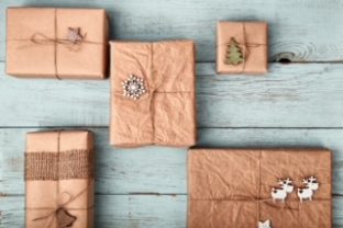 Christmas gift boxes wrapped in kraft paper on blue wooden table. Zero waste, eco friendly packaging.
