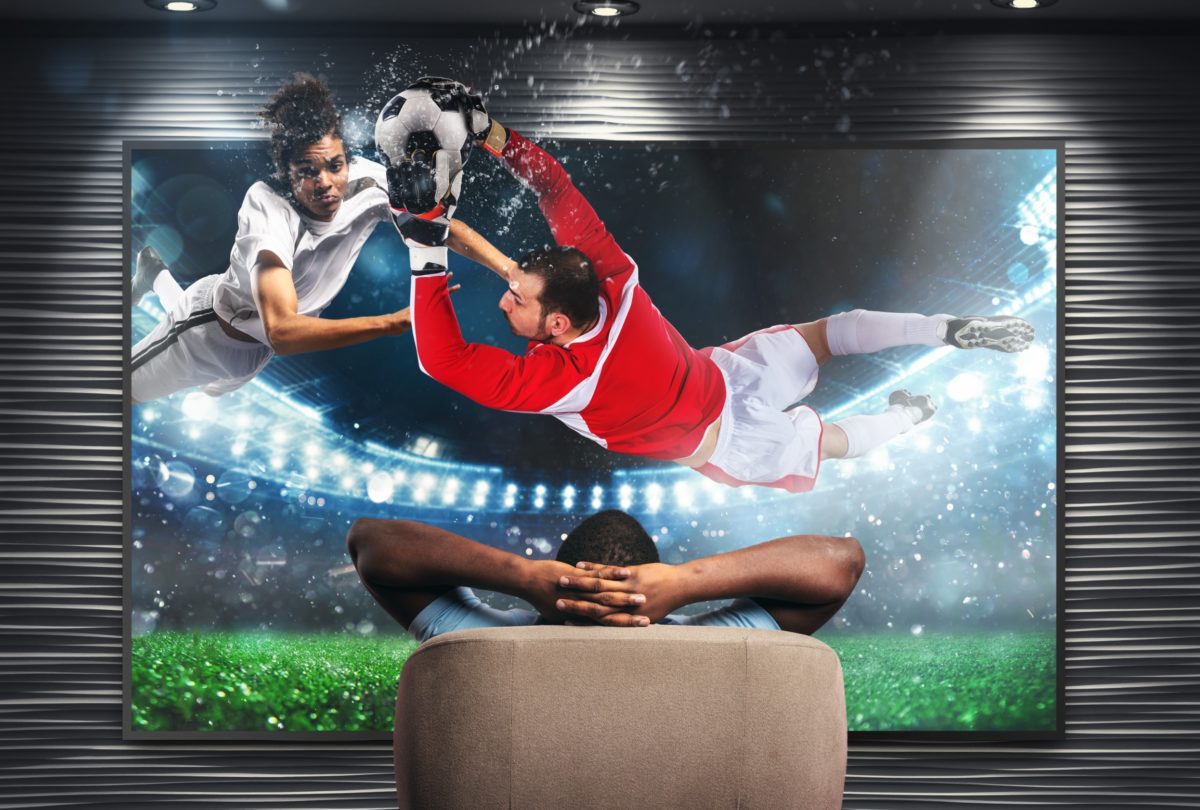 Viewer in front of a tv on the armchair at home feels inside the action