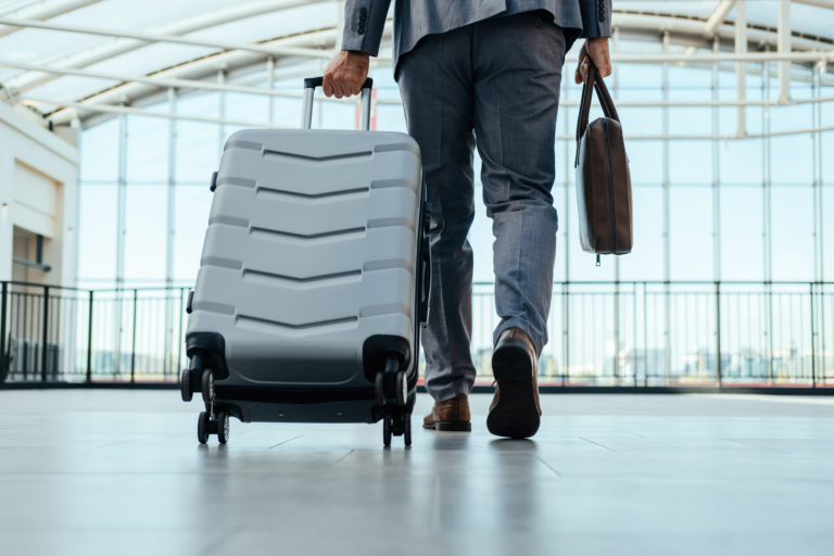 An Anonymous Business Man Walking With Luggage in the Airport