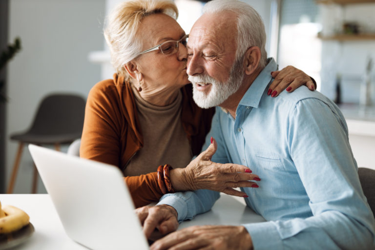 Mature,Woman,Kissing,Her,Mature,Husband,While,He,Uses,A