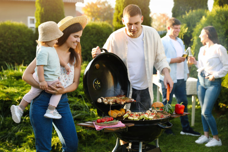 Family with friends having barbecue party outdoors