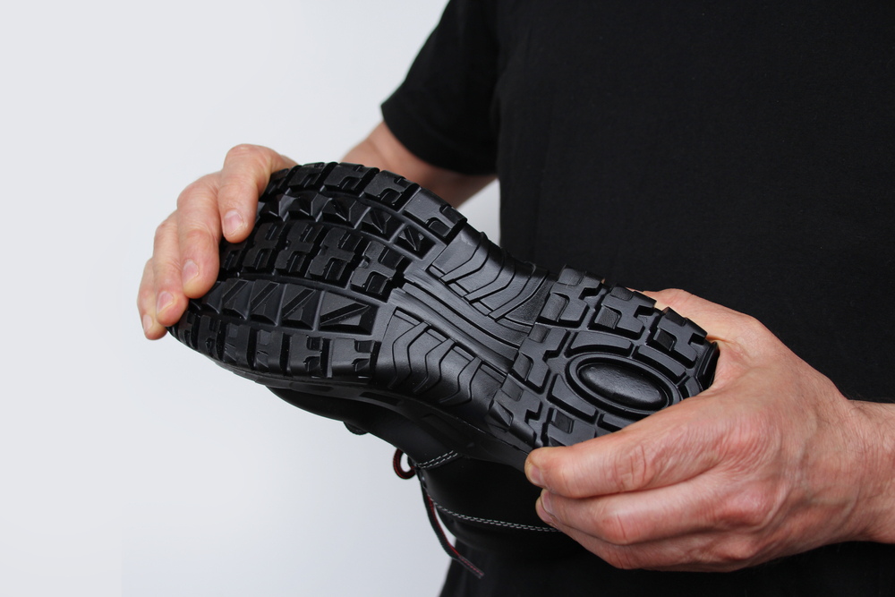 Man,Holds,In,His,Hands,A,Black,Work,Boot,Made