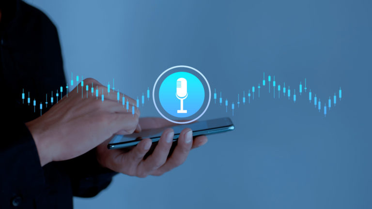 Hand holding smartphone with microphone icon on virtual screen