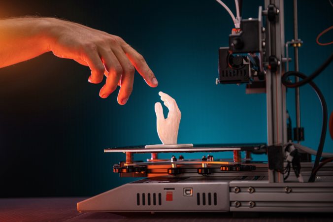 3D printing in progress. 3d printer printed a hand. A man touches the product printed on a 3d printer. God&#039;s touch, biblical motives