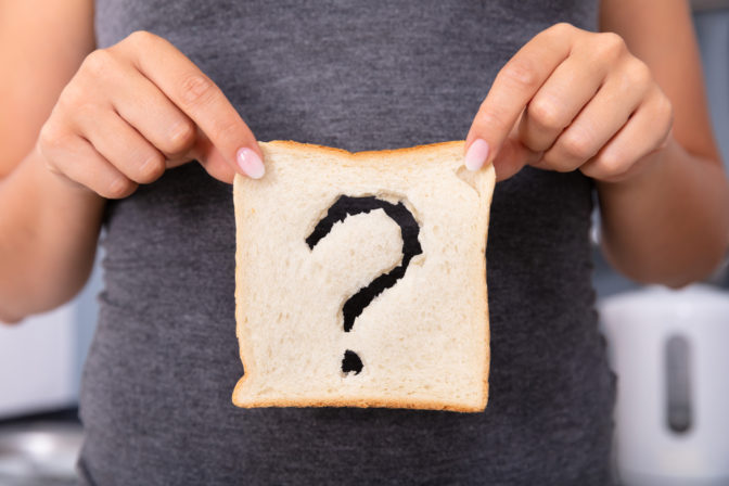 Woman Holding Slice Of Bread With Question Mark Sign