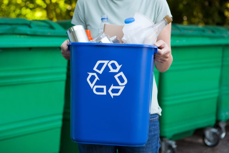 Close Up Of Woman Carrying Recycling Bin