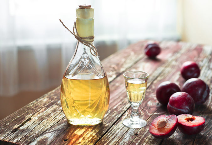 A bottle of plum brandy - rakija or rakia slivovica and fresh plums