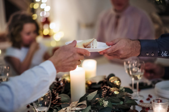 A multi generation family indoors celebrating Christmas together, midsection.