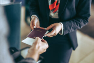 Ground staff checking passport of tourist at airport