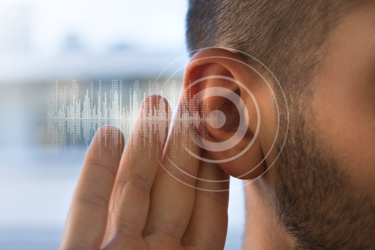 Young man with hearing problems or hearing loss. Hearing test concept.