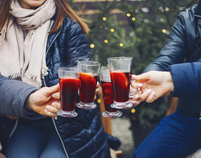 Friends drinking delicious mulled wine at party