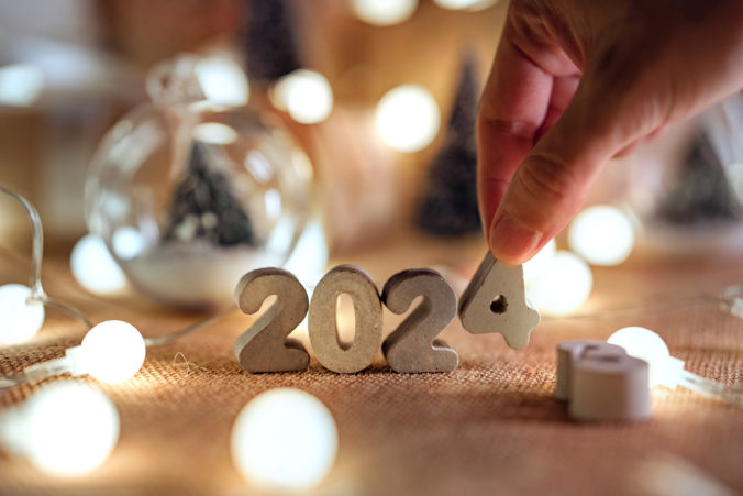 Hands of woman put 2024 numbers on decorated table, Merry Christmas and Happy New Year!