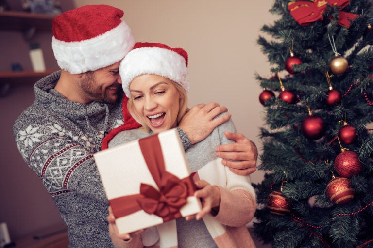 Handsome man is giving his girlfriend a gift box.