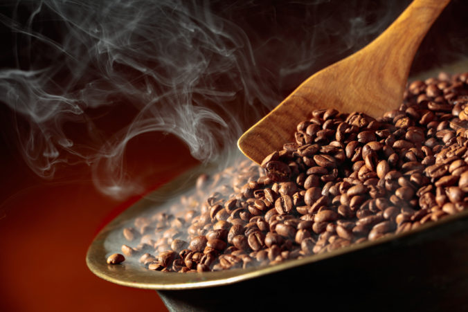 Coffee beans are smoky in a roasting pan.