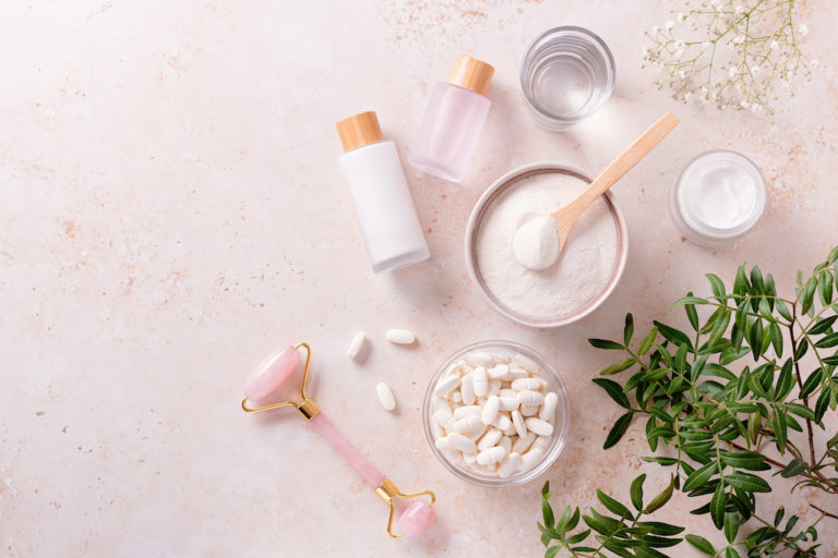 Different types of collagen for skin care and gua sha beauty roller flat lay, copy space