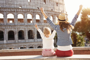 Mother and daughter travellers near Colosseum rejoicing