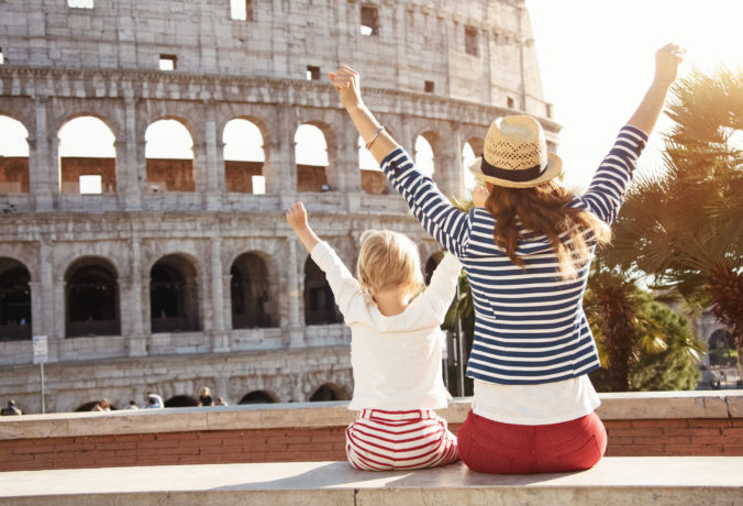 Mother and daughter travellers near Colosseum rejoicing