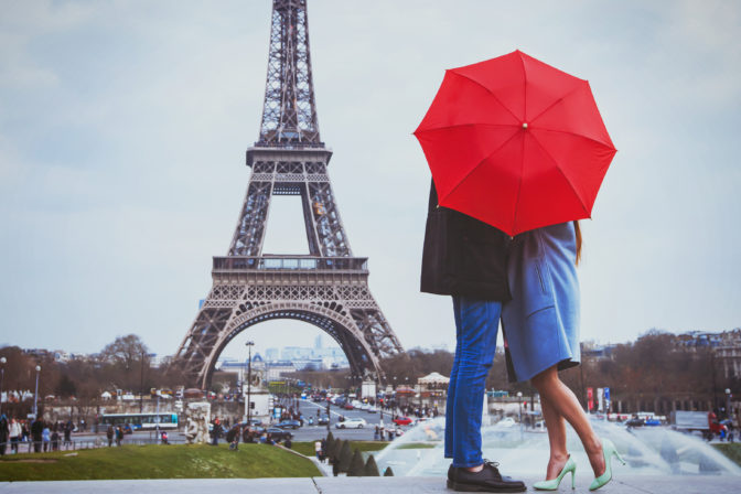 Rmantic couple in Paris kissing near Eiffel towe.