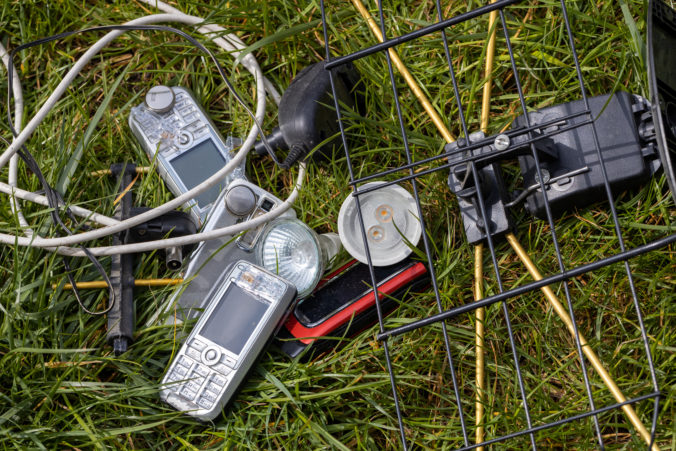 Electro waste, Old telephones, LEDs, chargers, cables scattered in the grass. The problem of littering and degradation of the environment, old or used electronic equipment