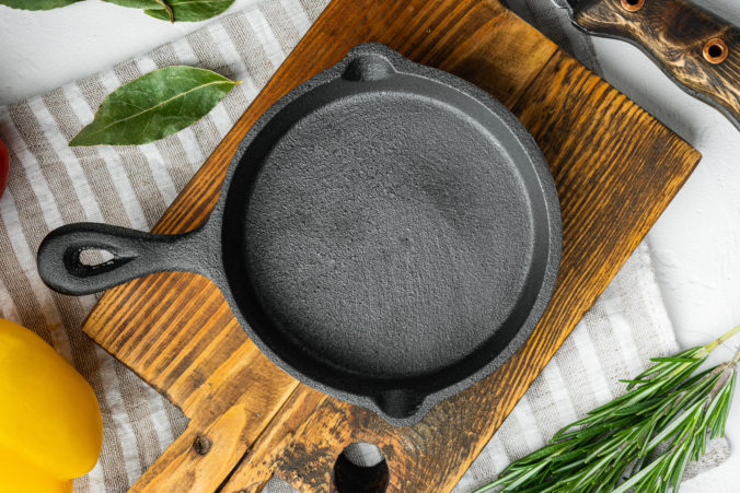 Empty frying cast iron pan background, kitchenware cooking concept, on white stone surface, top view flat lay, with copy space for text