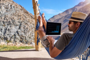 Digital nomad mature man in a lying in a hammock with a laptop