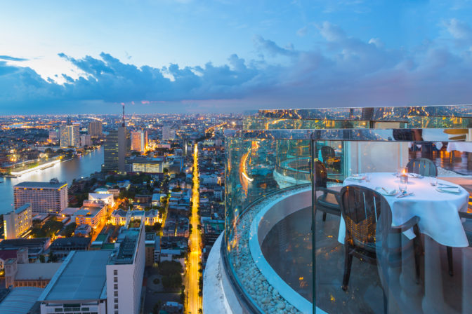 Dining table with beautiful city view on rooftop at twilight scene