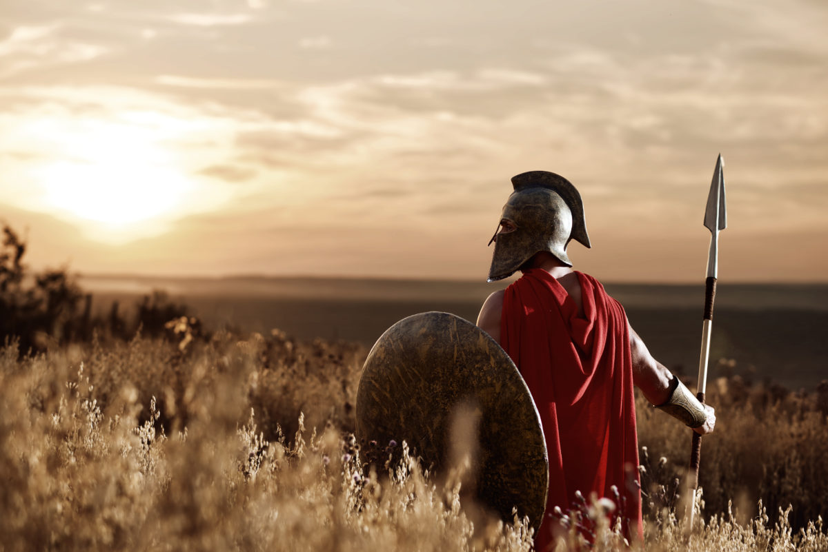 Warrior wearing iron helmet and red cloak.
