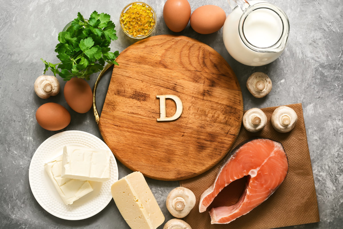 Empty cutting board and frame of varied food rich in vitamin D. Healthy eating concept. Top view, flat lay.