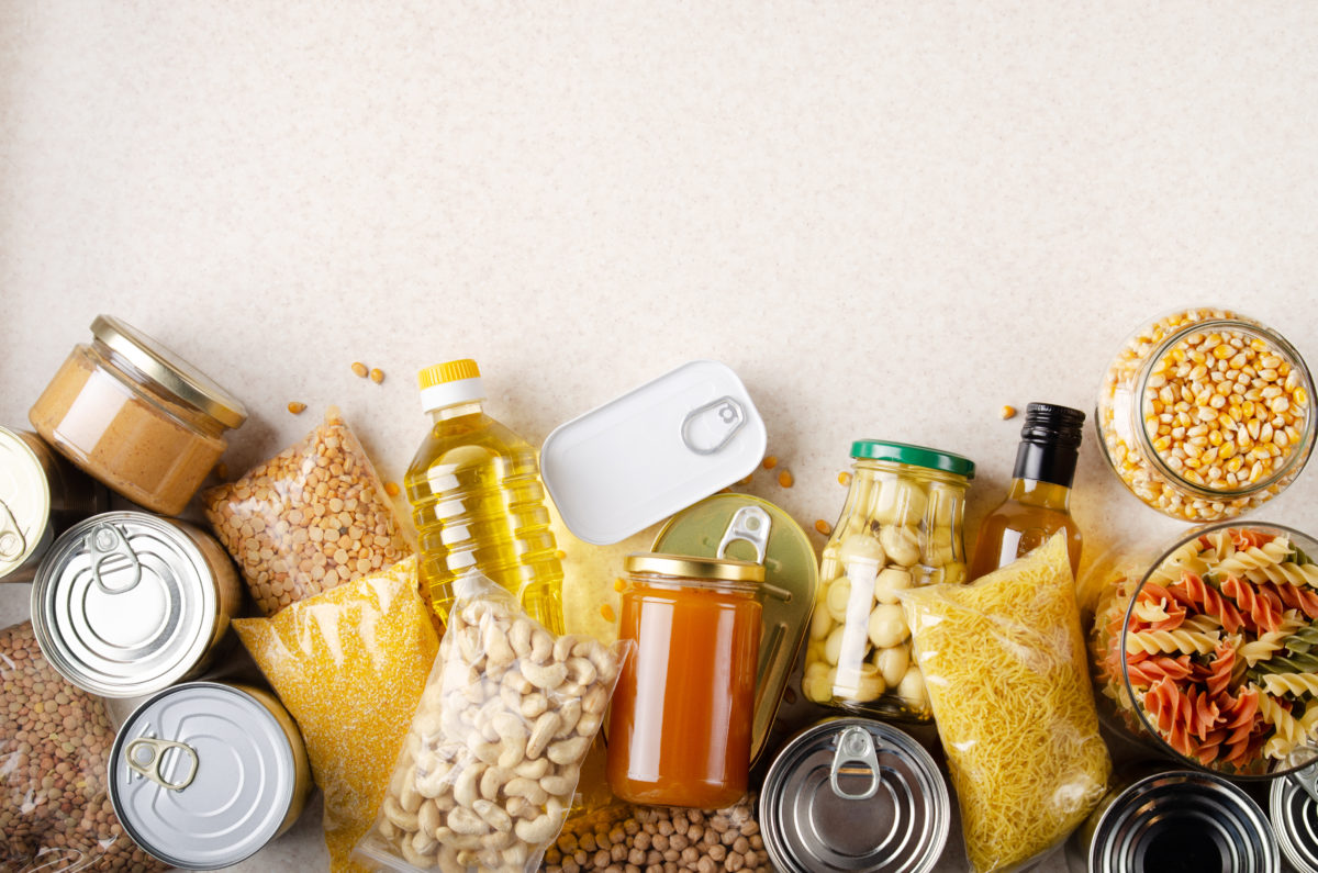 Flat lay view at kitchen table full with non perishable foods. Spase for text