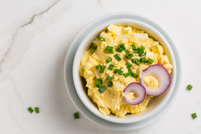 Egg spread with onion and chives on marble background