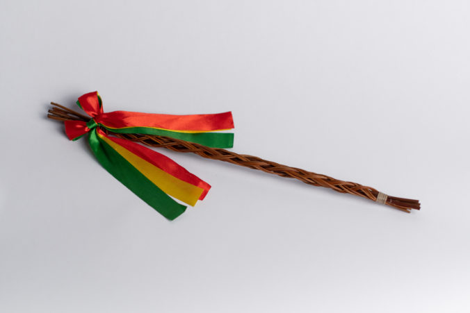 Slovak and Czech traditional handmade korbash or whip with green, red and yellow ribbon tied on it with isolated white backround.