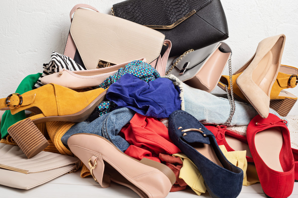 Fast fashion background with pile of cheap, low quality clothes. Garment made in inhumane conditions