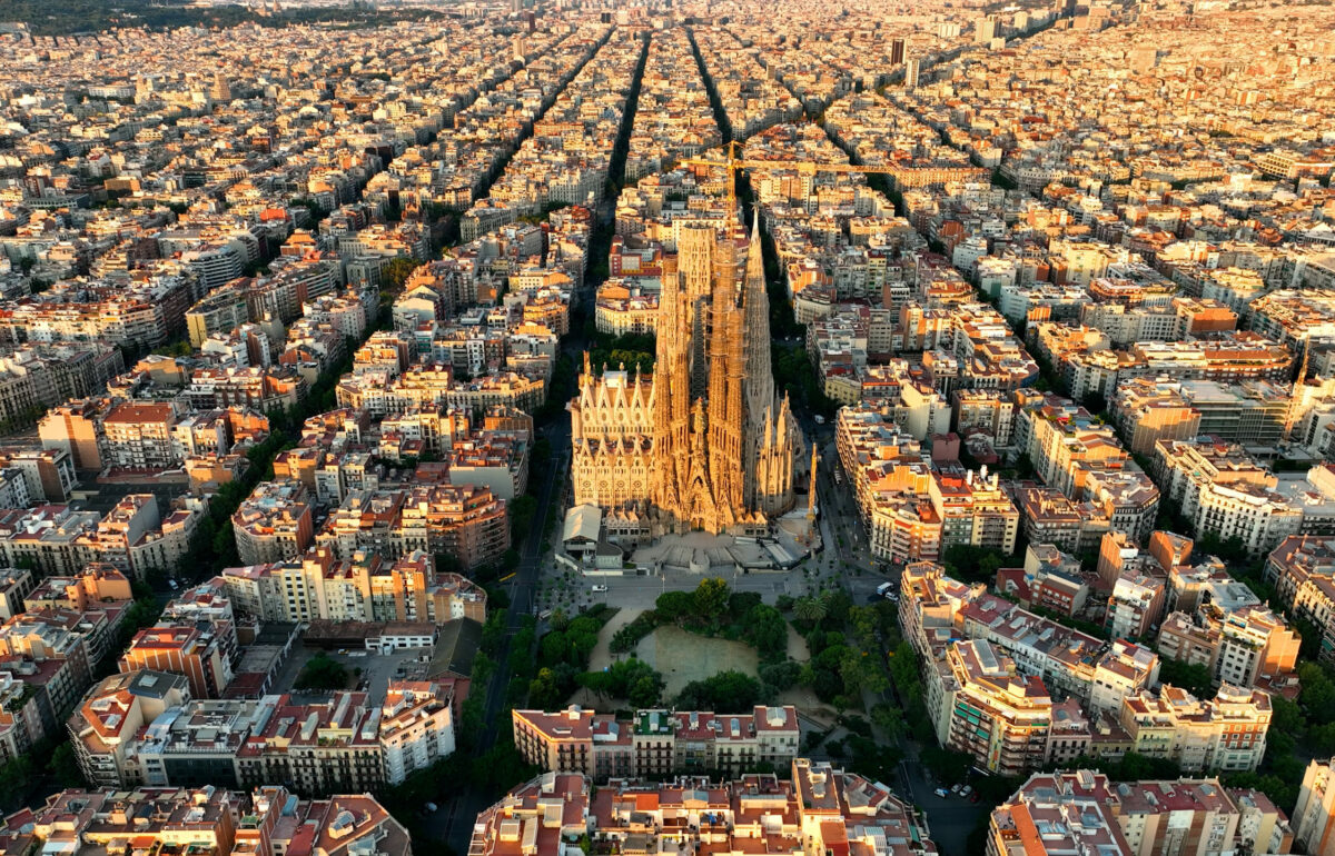 Aerial view of Barcelona city skyline and Sagrada Familia Cathedral at sunrise. Eixample residential famous urban grid. Cityscape with typical urban octagon blocks. Catalonia, Spain
