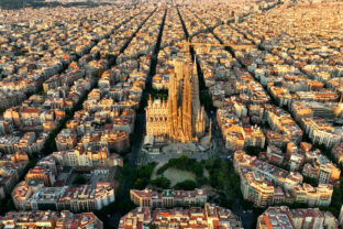 Aerial view of Barcelona city skyline and Sagrada Familia Cathedral at sunrise. Eixample residential famous urban grid. Cityscape with typical urban octagon blocks. Catalonia, Spain