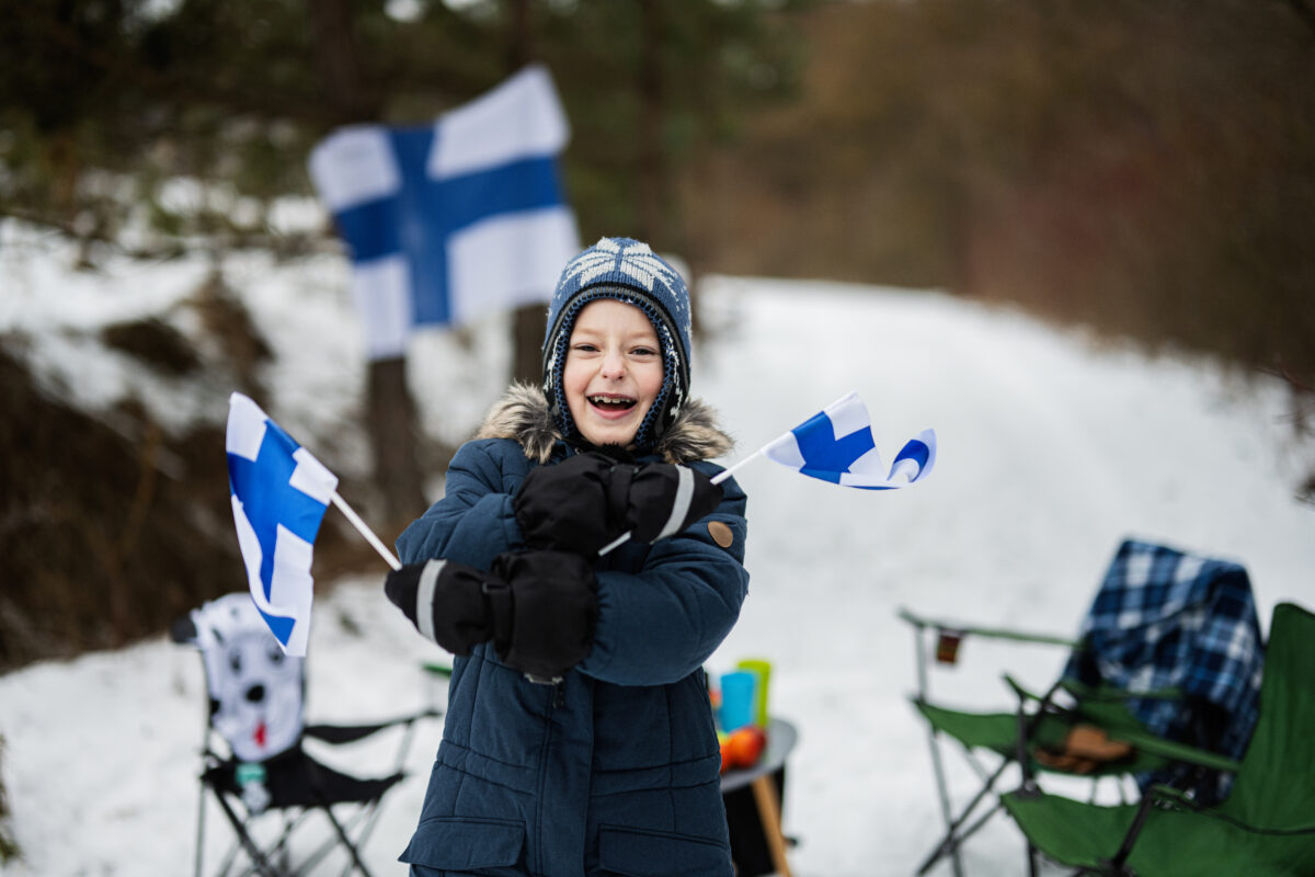 Finnish boy with Finland flags on a nice winter day. Nordic Scandinavian people.