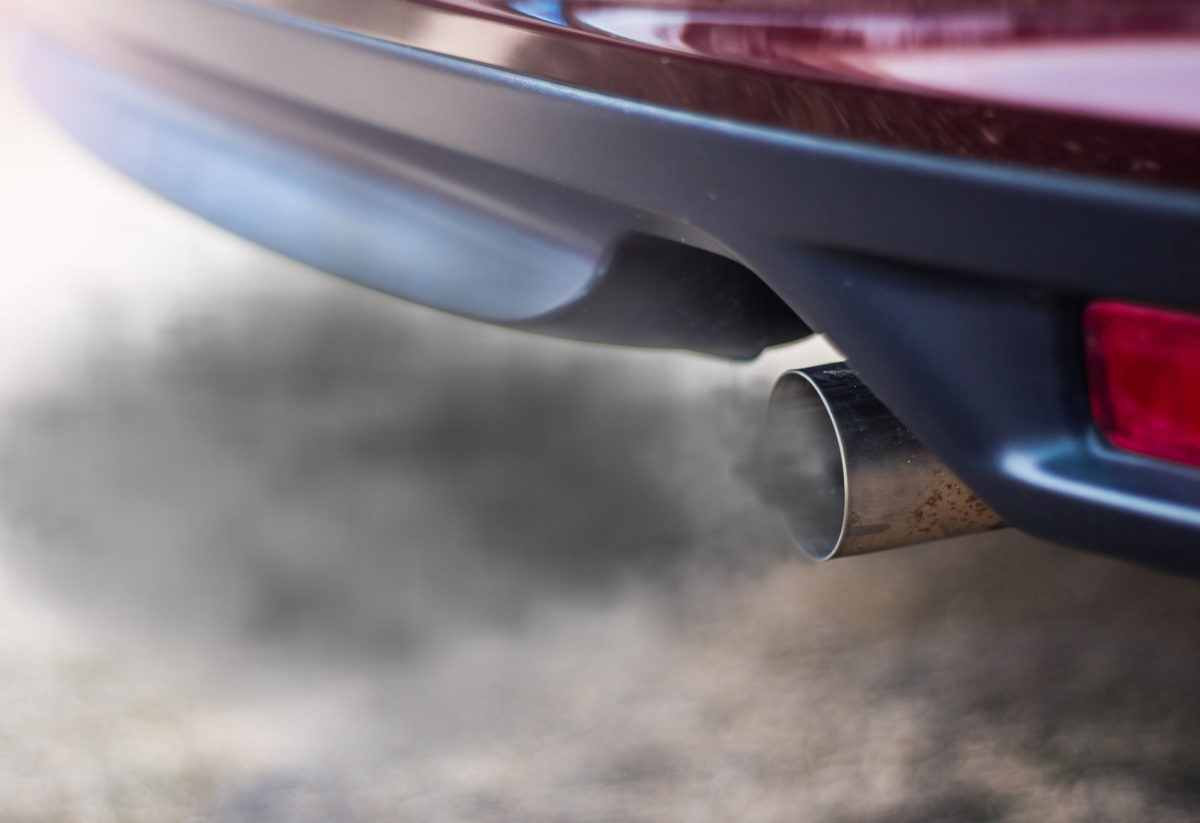Combustion fumes coming out of car exhaust pipe